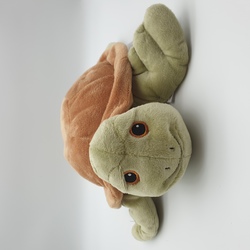 Ein weiches, grünes Kuscheltier in Form einer Schildkröte.